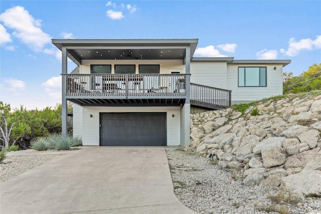 view of front of property featuring an attached garage, ceiling fan, and concrete driveway