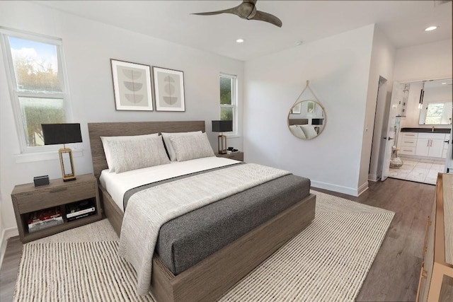 bedroom featuring baseboards, dark wood finished floors, connected bathroom, ceiling fan, and recessed lighting