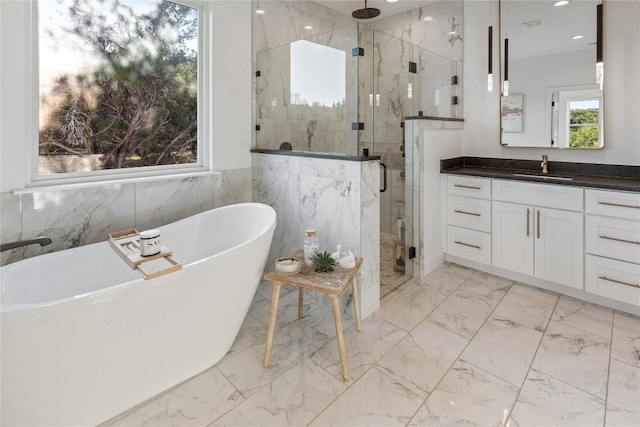 full bathroom featuring a soaking tub, marble finish floor, vanity, a shower stall, and recessed lighting