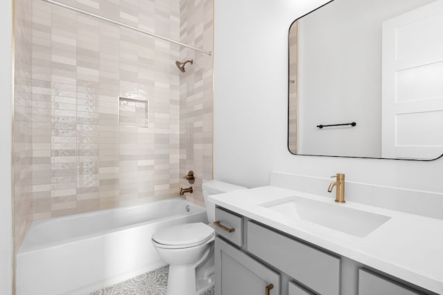 full bathroom featuring tiled shower / bath combo, vanity, and toilet