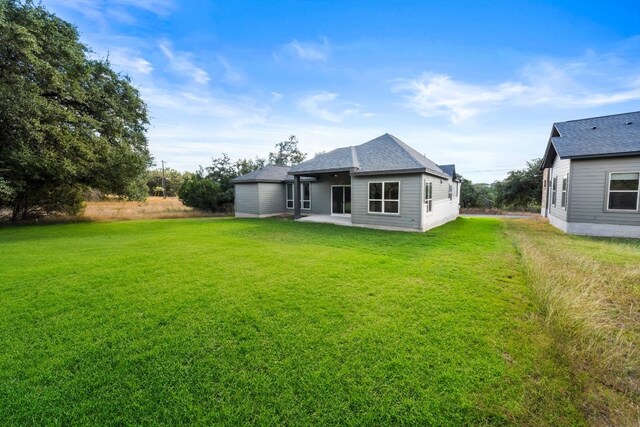 back of house featuring a patio area and a lawn