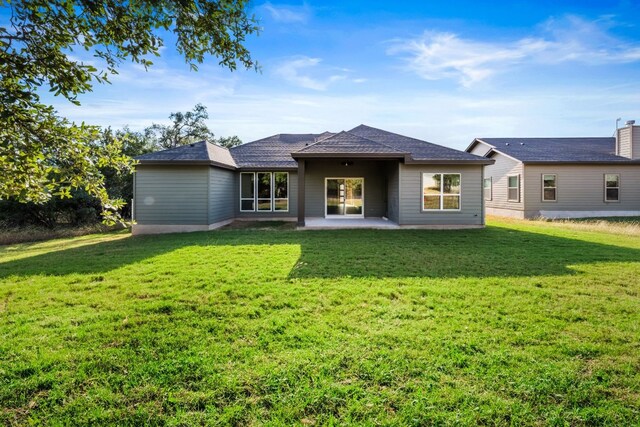 rear view of house with a yard and a patio area