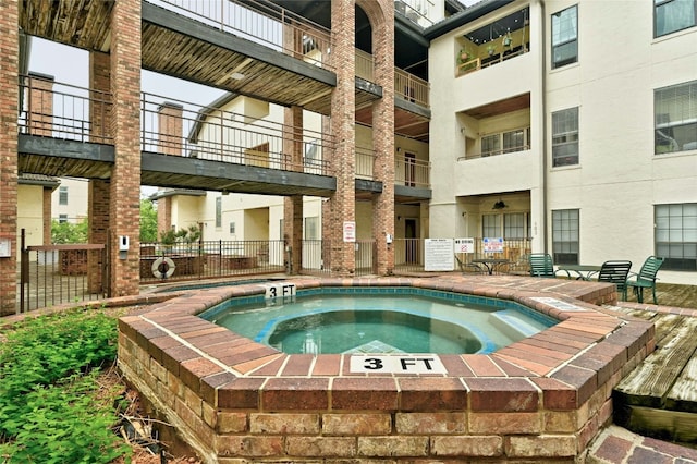 view of swimming pool featuring a hot tub