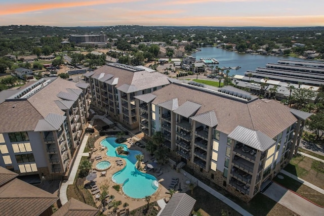 aerial view at dusk featuring a water view