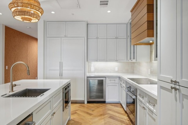 kitchen featuring sink, white cabinetry, stainless steel oven, light parquet flooring, and beverage cooler