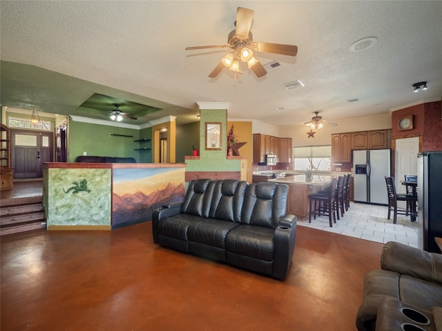 living room featuring ornamental molding, ceiling fan, and a textured ceiling