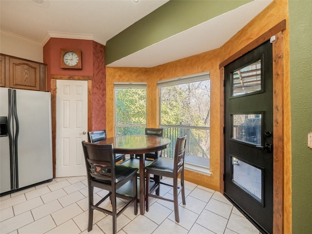 dining space with light tile patterned flooring and ornamental molding