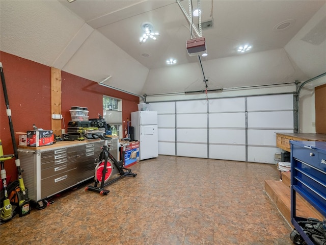 garage with a garage door opener and white fridge