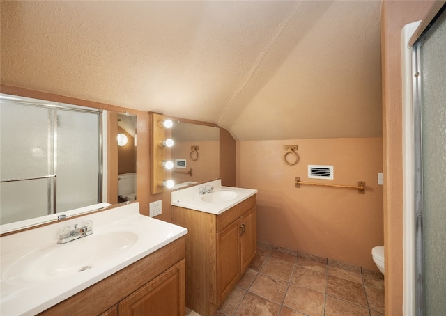 bathroom with vanity, a shower with shower door, lofted ceiling, and toilet