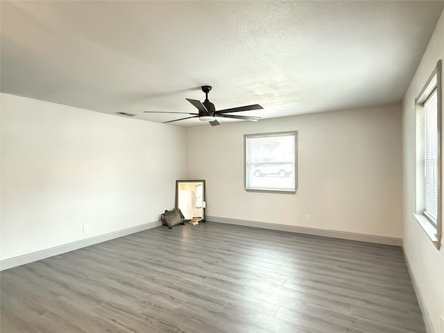 spare room featuring ceiling fan, hardwood / wood-style floors, and a textured ceiling