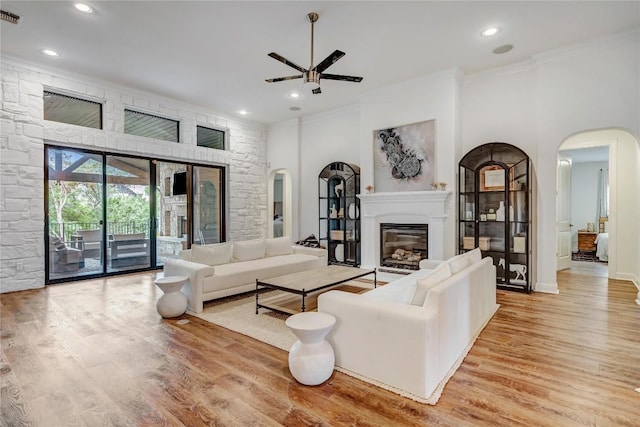 living room featuring crown molding, ceiling fan, and light hardwood / wood-style floors