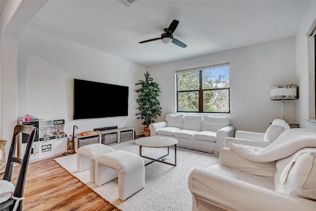 living room with light hardwood / wood-style floors and ceiling fan