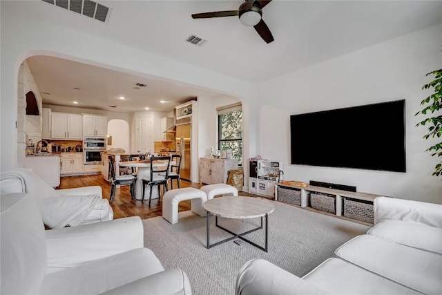 living room featuring ceiling fan and light hardwood / wood-style floors