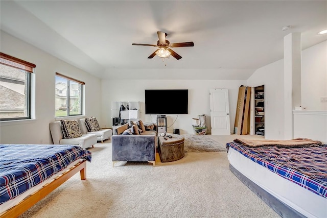 carpeted bedroom with ceiling fan and vaulted ceiling