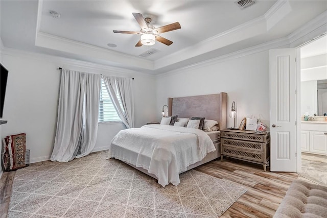 bedroom featuring light hardwood / wood-style flooring, ornamental molding, a raised ceiling, and ceiling fan