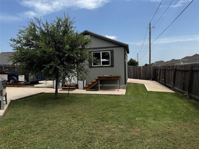 rear view of property featuring a lawn and a patio