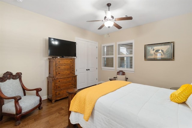 bedroom featuring hardwood / wood-style flooring, ceiling fan, and a closet