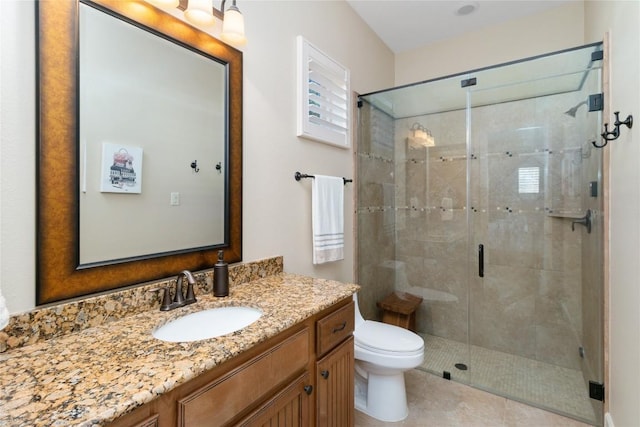 bathroom featuring vanity, toilet, tile patterned floors, and a shower with shower door