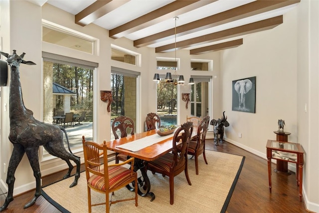 dining room with beamed ceiling and dark hardwood / wood-style flooring