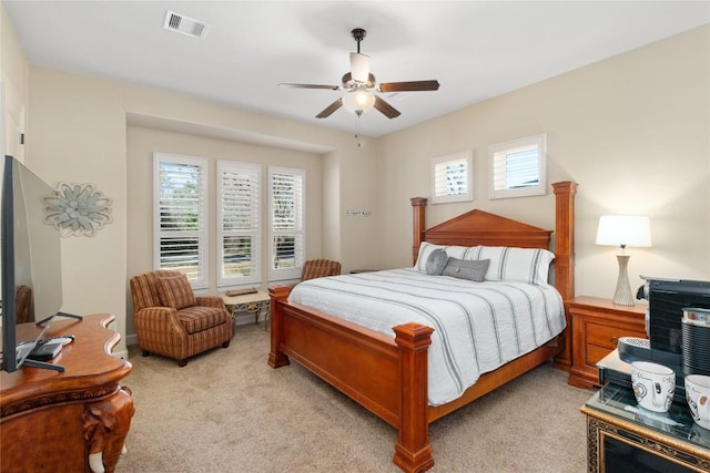 carpeted bedroom with multiple windows and ceiling fan