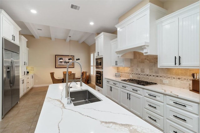 kitchen featuring sink, white cabinetry, built in appliances, light stone counters, and light tile patterned flooring