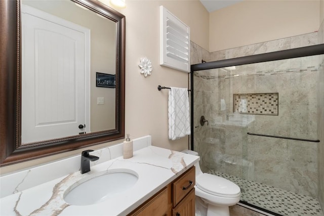 bathroom featuring vanity, toilet, and an enclosed shower