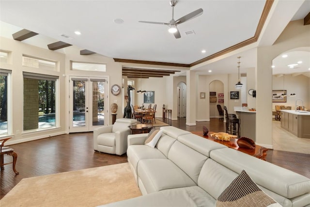 living room with sink, crown molding, a wealth of natural light, and wood-type flooring