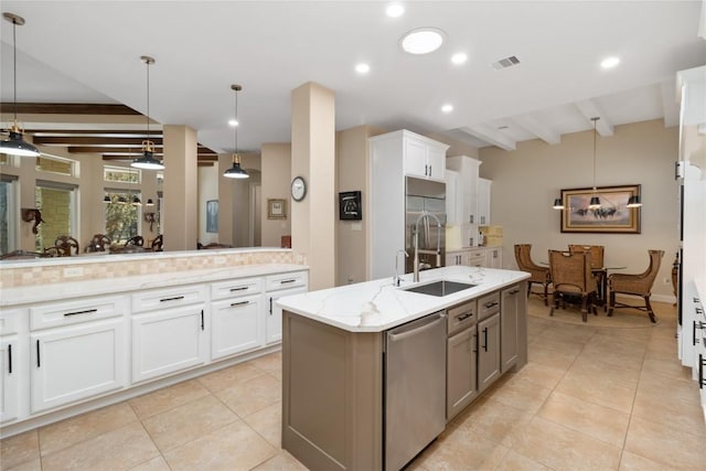 kitchen featuring white cabinetry, appliances with stainless steel finishes, a kitchen island with sink, and pendant lighting