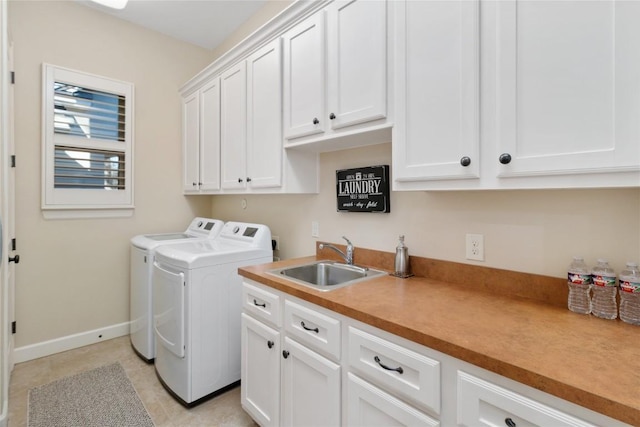 laundry area with light tile patterned flooring, cabinets, washer and clothes dryer, and sink