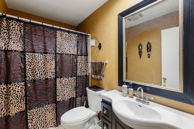 bathroom with vanity, walk in shower, and toilet