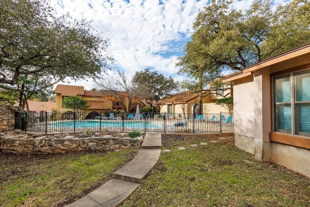 view of pool featuring a lawn