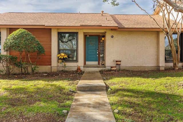 view of exterior entry with a yard