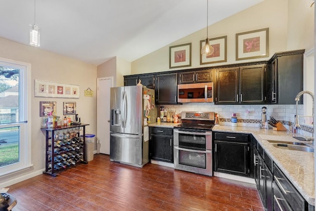 kitchen featuring pendant lighting, sink, appliances with stainless steel finishes, dark hardwood / wood-style floors, and light stone counters