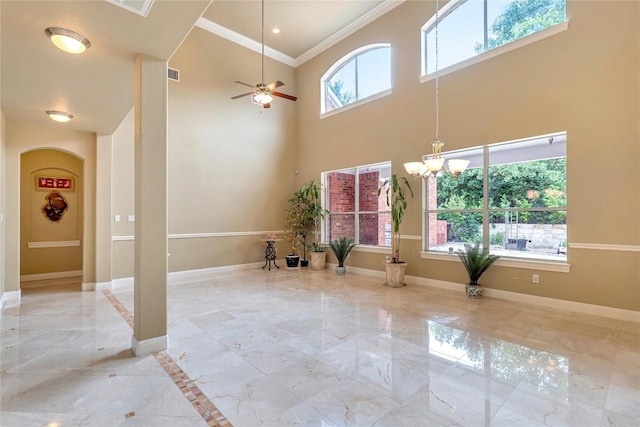 interior space with crown molding, ceiling fan with notable chandelier, and a towering ceiling