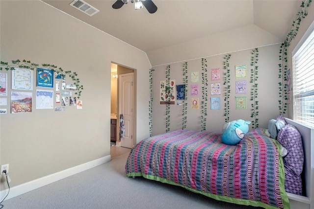 bedroom featuring vaulted ceiling, light colored carpet, ceiling fan, and ensuite bath