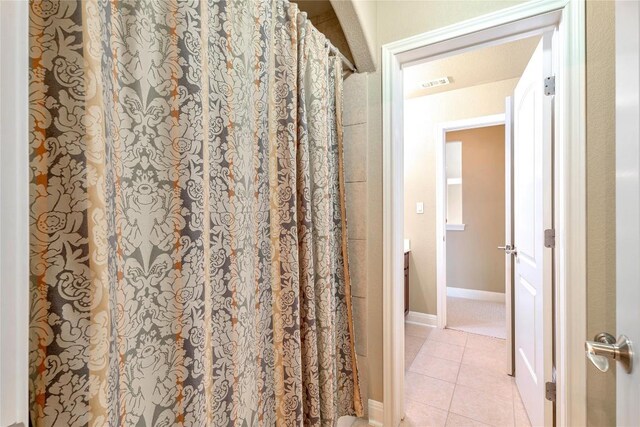 bathroom with a shower with curtain and tile patterned flooring