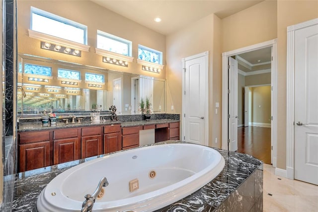 bathroom with ornamental molding, vanity, tiled bath, and tile patterned floors