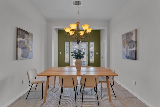 tiled dining room featuring a chandelier