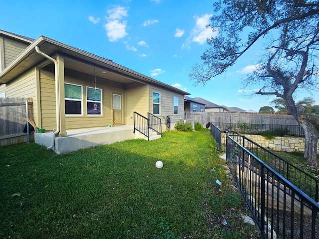 rear view of house with a patio area and a lawn