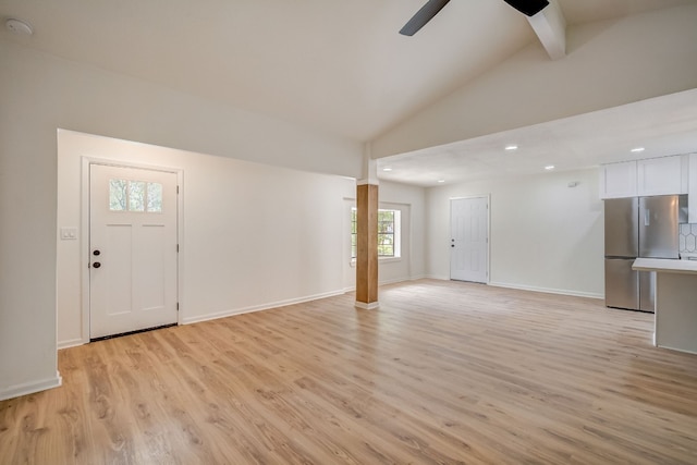 unfurnished living room featuring ceiling fan, light hardwood / wood-style flooring, and vaulted ceiling with beams