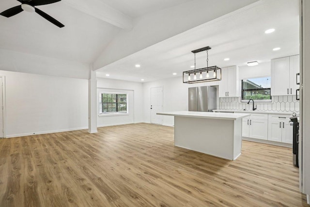 6009 Glen Meadow Dr, Austin, TX 78745 - kitchen featuring open floor plan, freestanding refrigerator, a kitchen island, light wood-type flooring, and recessed lighting