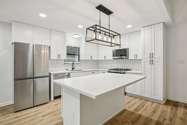 6009 Glen Meadow Dr, Austin, TX 78745 - kitchen with stainless steel appliances, light wood-style flooring, light countertops, tasteful backsplash, and recessed lighting