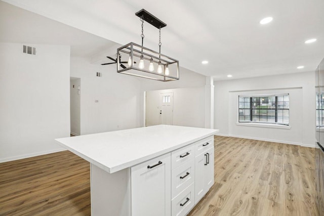 6009 Glen Meadow Dr, Austin, TX 78745 - kitchen with light wood-style floors, open floor plan, white cabinetry, recessed lighting, and light countertops