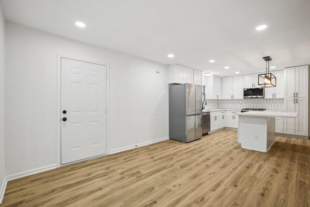 6009 Glen Meadow Dr, Austin, TX 78745 - kitchen featuring stainless steel appliances, light wood-style flooring, white cabinets, decorative backsplash, and recessed lighting