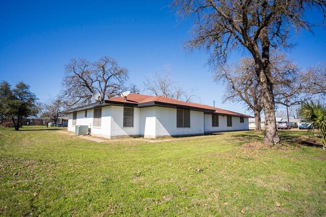 view of property exterior featuring central AC unit and a lawn