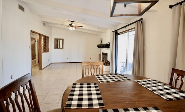 dining space featuring lofted ceiling with beams, light tile patterned flooring, and ceiling fan