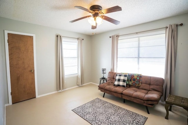 living room with ceiling fan and a textured ceiling