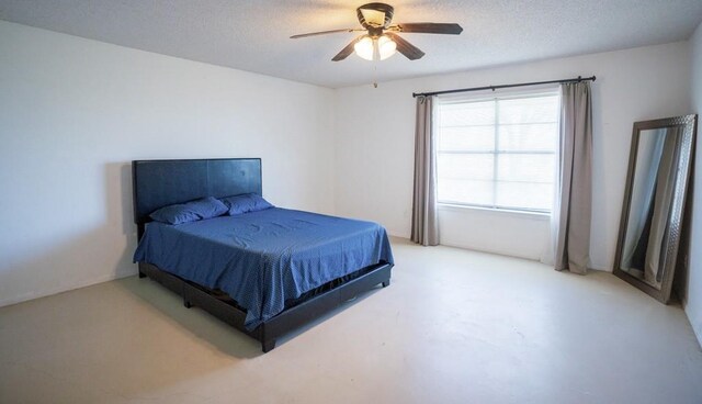 bedroom with ceiling fan and a textured ceiling