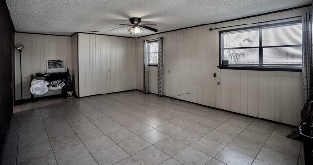 empty room with a textured ceiling and ceiling fan