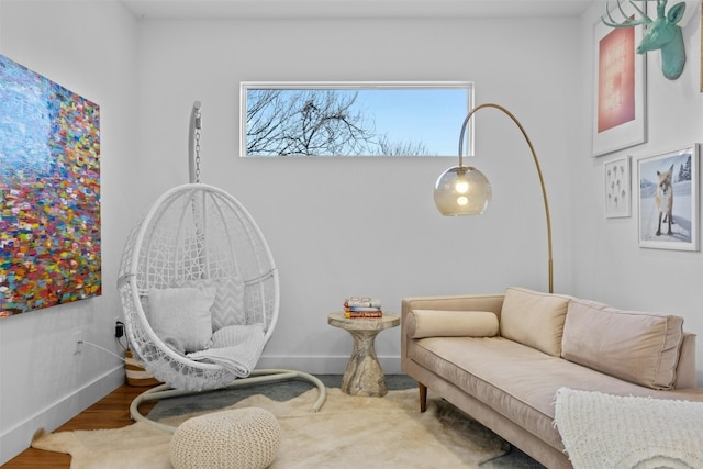 living area featuring baseboards and wood finished floors